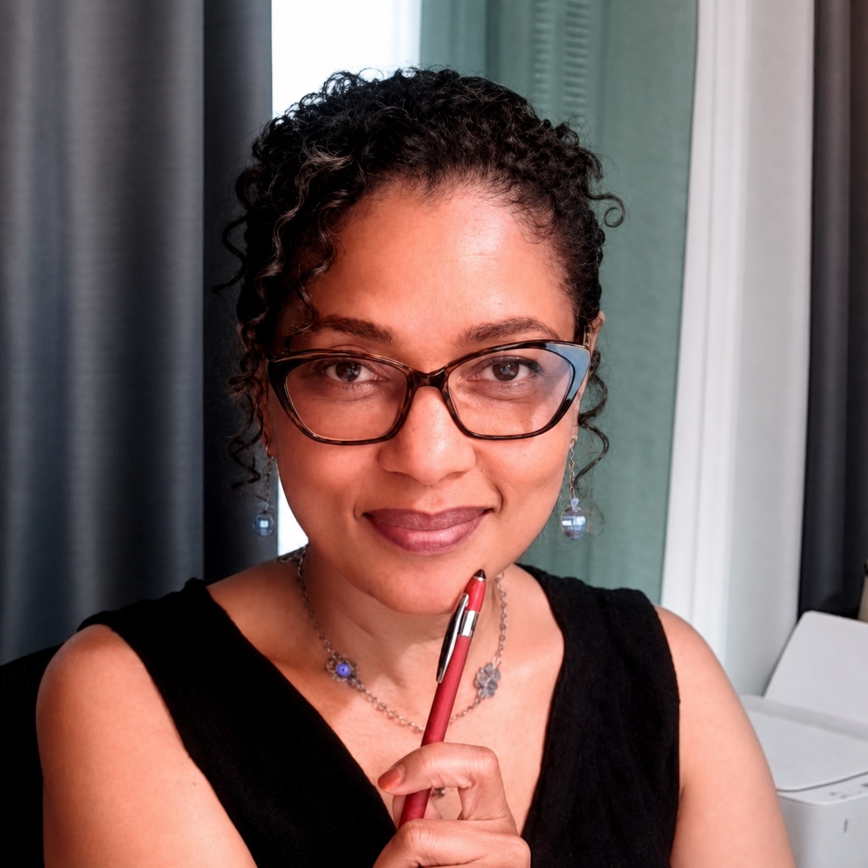 Naomi V. Dunsen-White smiling with a pen in hand