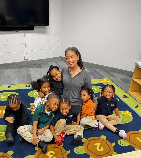 Naomi V. Dunsen-White seated with a group of preschool students