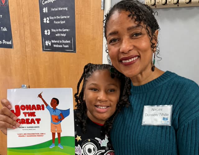 Naomi V. Dunsen-White with a young reader holding Johari the Great
