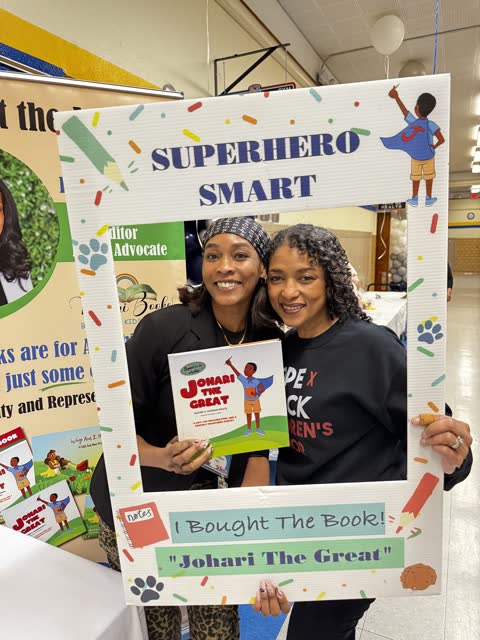 Naomi V. Dunsen-White and a guest holding Johari the Great inside a celebratory photo frame