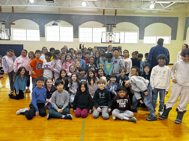 Naomi V. Dunsen-White with a large group of students in the Novi Woods school gym