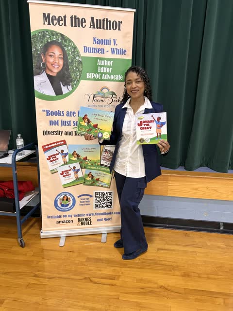 Naomi V. Dunsen-White holding her books beside a Meet the Author banner