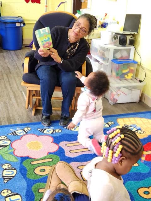 Naomi V. Dunsen-White sharing a board book with toddlers