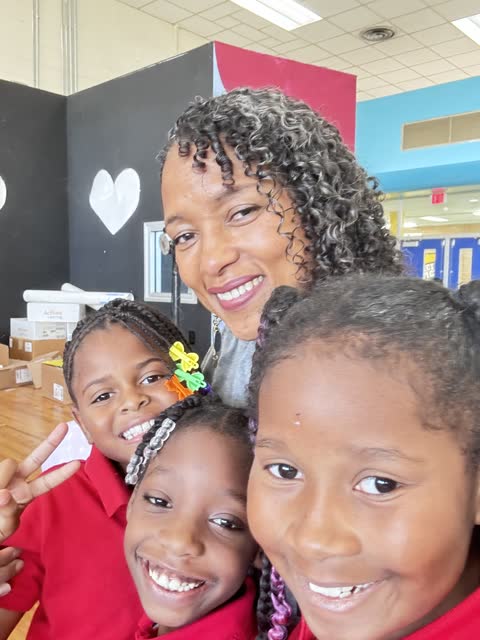 Naomi V. Dunsen-White smiling with three young readers