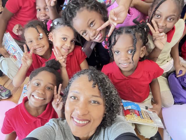 Naomi V. Dunsen-White taking a group selfie with smiling young readers